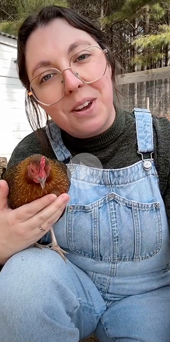 Image of woman in overalls holding a chicken